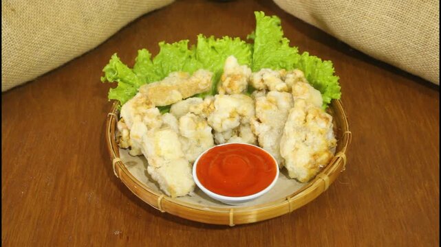 Serving Crispy Fried Tofu with Chili Sauce on Traditional Bamboo Plate