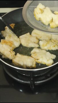 Removing Crispy Golden Fried Tofu from Hot Sizzling Oil Pan