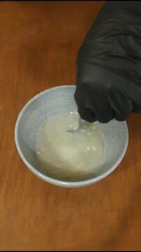 Hand in Black Glove Stirring Flour and Spices Mixture in Bowl