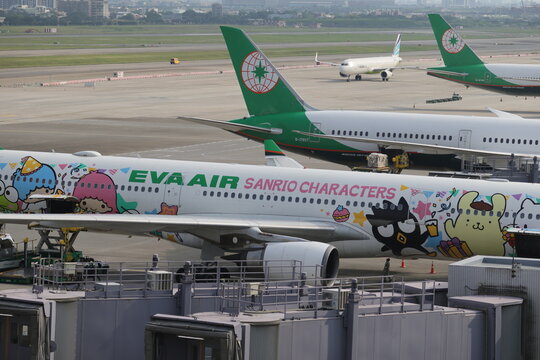 EVA Air Sanrio Characters livery aircraft parked at the airport terminal for ground operations and cargo loading.