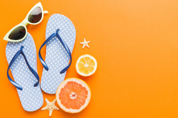 Naklejka premium Top view composition of flip flops placed with beach accessories top view on table background. Tropical summer vacation concept Flat lay