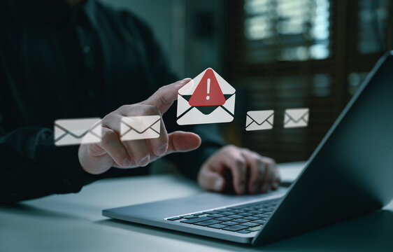 Person using laptop and selecting warning email icon on virtual interface, representing phishing alert, suspicious message detection, cybersecurity risk, email security, and online fraud prevention.