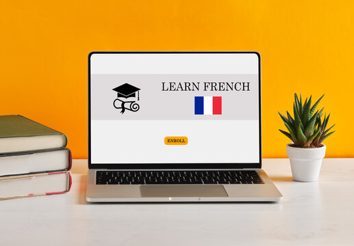 Learning French with online courses on laptop with France flag on screen