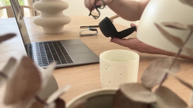 Putting glasses into case after work in minimalist home office