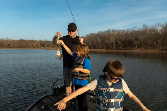 Happy father and sons showing off a small fish they caught
