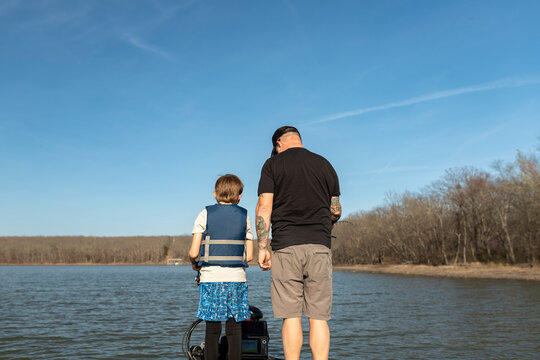 Man and son standing together on a boat deck during a fishing trip