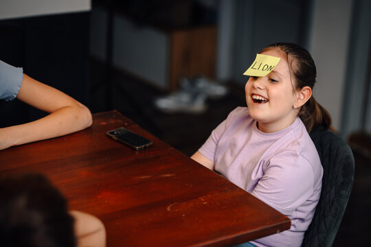 Young child laughing playing guessing game at home