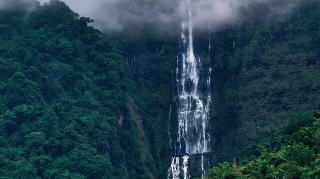 Aerial view misty foggy mountain landscape with clouds and waterfall
