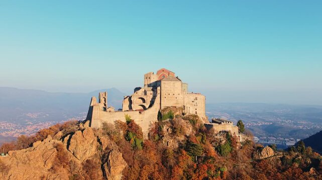 Aerial: establishing drone shot of Saint Michael's Abbey at sunset in Sant'Ambrogio di Torino, Piedmont, Italy