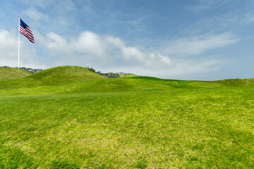 Fototapeta premium Green grass hill under blue sky minimal landscape background