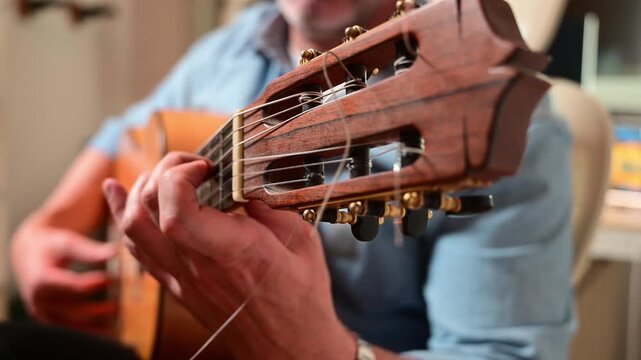 Professional musician tuning a classical acoustic guitar
