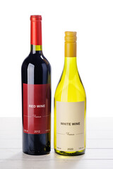 Naklejka premium Red and white wine bottles on wooden table