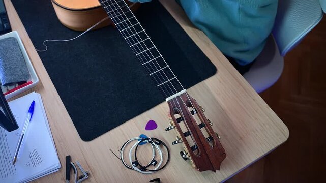 Musician changing the nylon string on a classical guitar