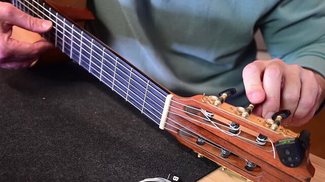 Luthier tuning a classical nylon string guitar