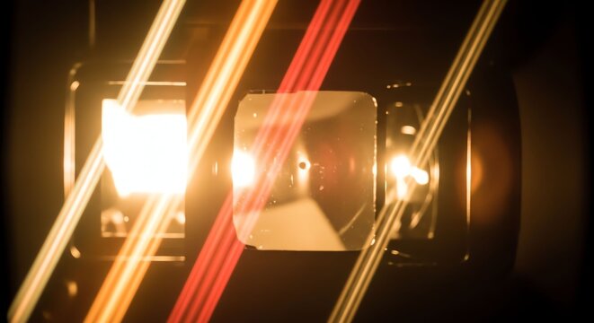 Close-up of a camera lens with light reflections and glare effects.