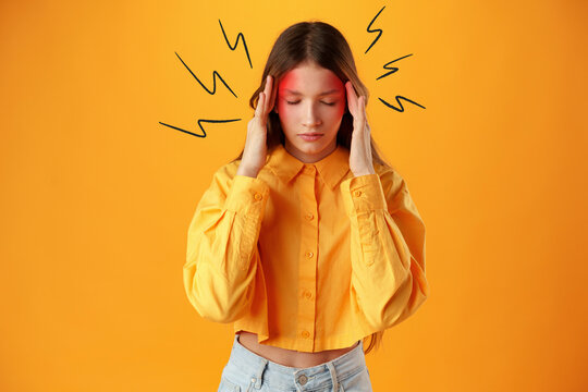 Young person holding head to show discomfort against bright background