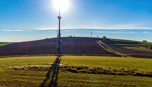 Cell tower in green field landscape.
