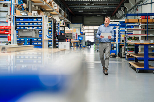 Manager inspecting production hall with tablet