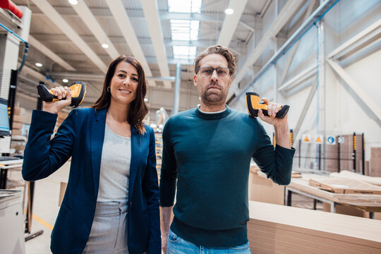 Business colleagues with bar code readers standing in workshop