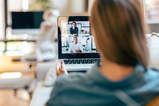 Woman participating in videochat on laptop at home