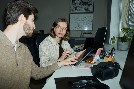 Programmer discussing digital project on tablet in office