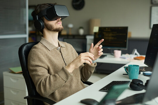 Programmer working with VR headset at desk