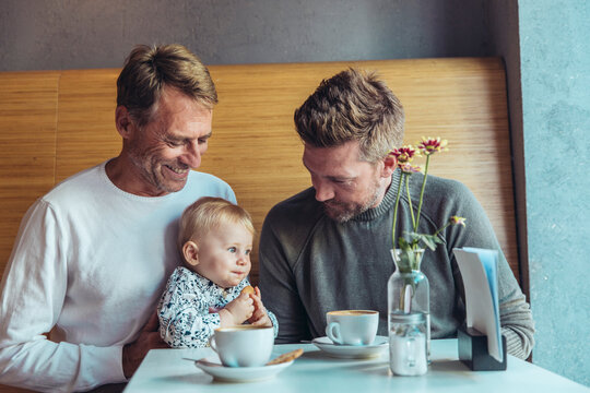 Couple with toddler enjoying coffee and family time in cafe