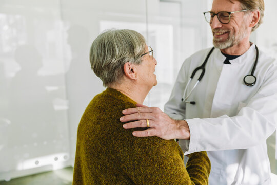 Doctor comforting senior patient during consultation at the hospital