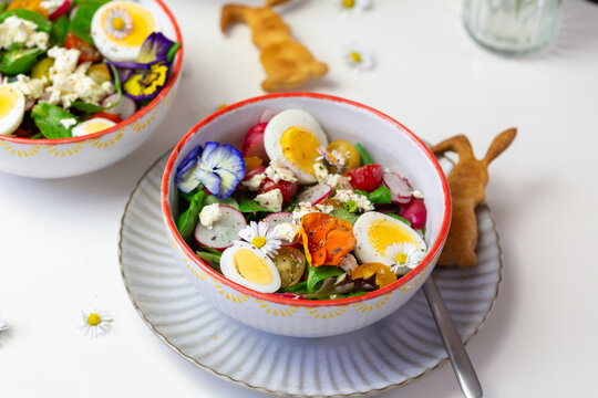 Fresh Easter salad with egg, radish, tomato and edible flower