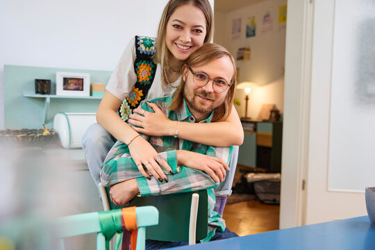 Happy man and woman sitting together at home