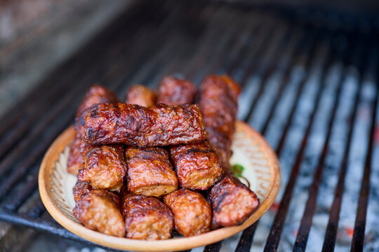 (Mici) cooks placed on a clay plate on a grill