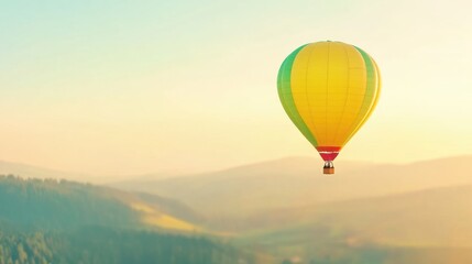Fototapeta premium A vibrant hot air balloon soars above lush green hills, bathed in soft morning light, creating a serene and picturesque view