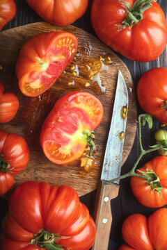 Cut heirloom tomato on wooden board with visible seeds and pulp. Fresh organic vegetable detail, healthy food preparation