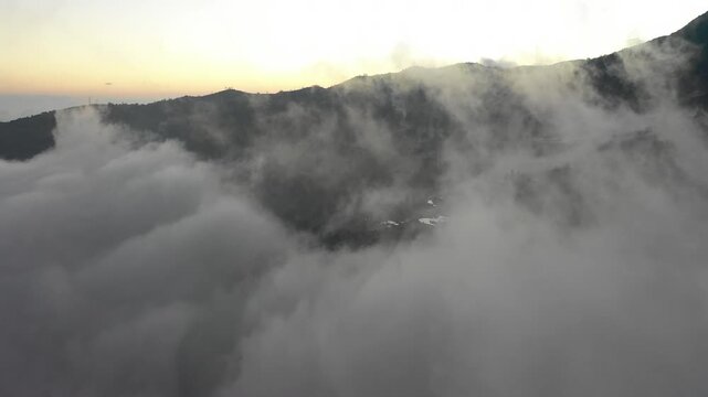 Drone flight through spectacular low hanging clouds reveals beautiful rice terraces in Yuanyang, one of China's most famous landscapes