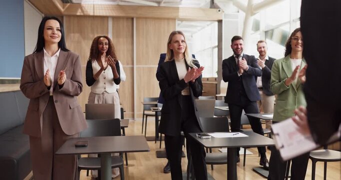 Audience professionals team seminar presentation recognition applause. Employees stand and clap for a corporate speaker, celebrating success and feedback. Clear idea of recognition and success.