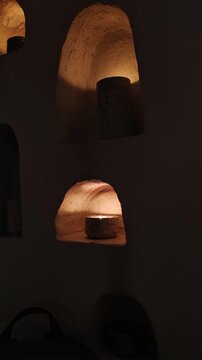 Candles Burning In Wall Niches Creating Warm Ambient Lighting. Decorative lighting design element for spa, restaurant or home interior atmosphere.