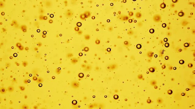 Macro shot of sunflower oil bubbles on golden background, abstract liquid texture, cooking ingredient detail, fluid pattern design.