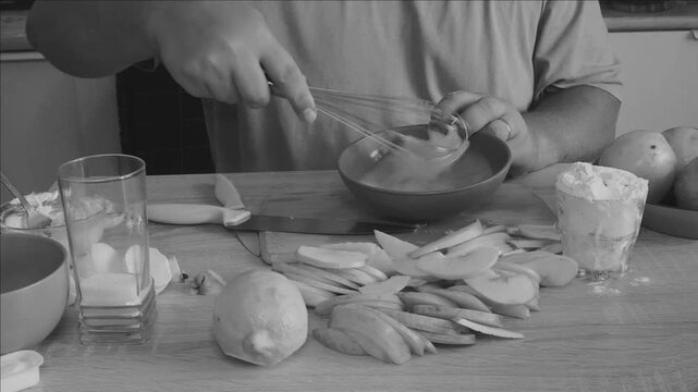 A man prepares a dough for baking buns and apple pie
