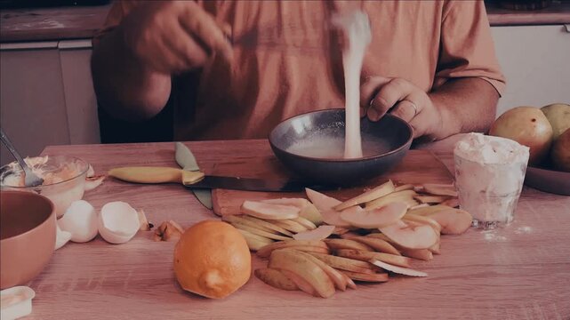 a man cuts the dough with a knife to make a homemade apple pie and