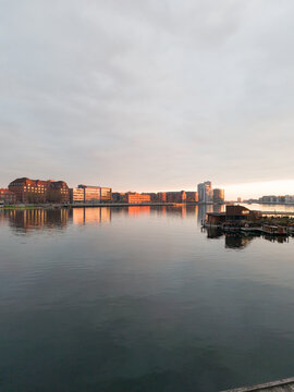 Modern waterfront architecture in Copenhagen at sunset, buildings reflecting on the canal