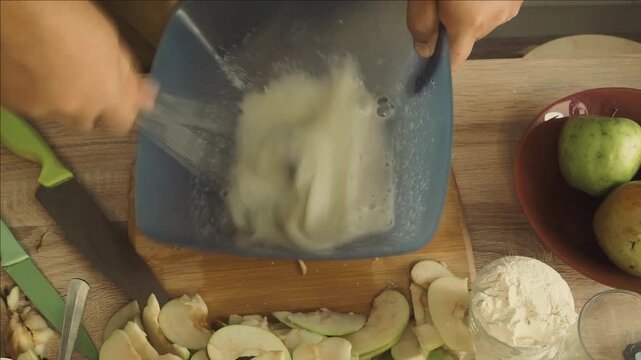 a man cuts the dough with a knife to make a homemade apple pie and