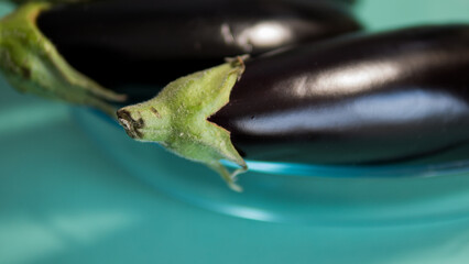 Naklejka premium Fresh eggplants in glass bowl close up organic vegetables cooking concept