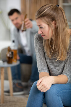 serious sad woman thinking over a problem man drinks alcohol