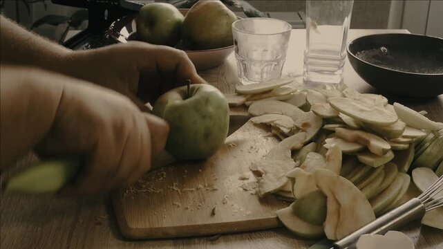 Close up of man's hands cutting red apple on the cutting board