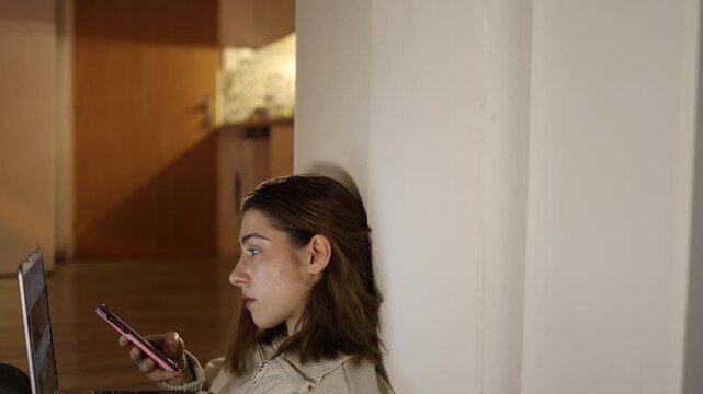 Woman with ADHD working on laptop at home constantly distracted by smartphone multitasking instead of focusing on tasks showing attention issues reduced productivity and digital overload