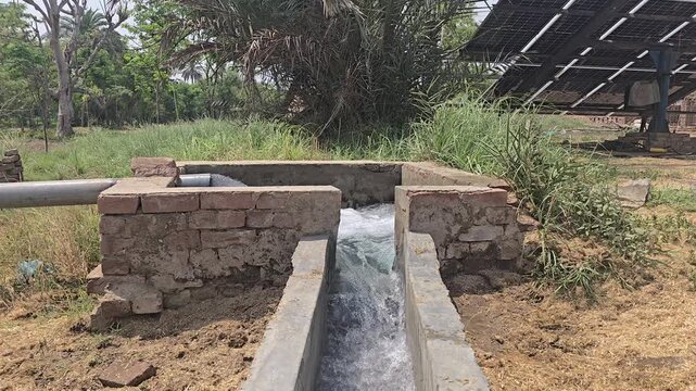 Solar powered water pump irrigation system in rural farm, sustainable agriculture with solar panels, clean energy water flow for farming