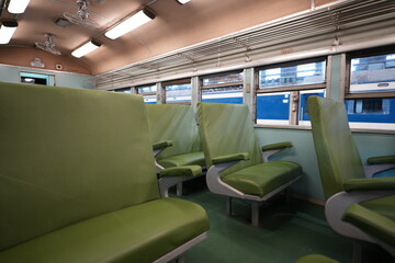 Fototapeta premium Interior of a vintage train carriage with green seats.