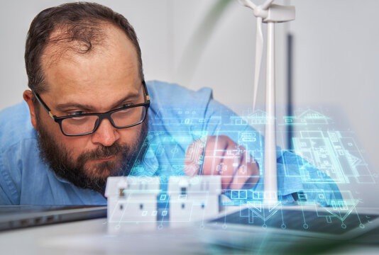 Engineer examining holographic smart city blueprint indoors