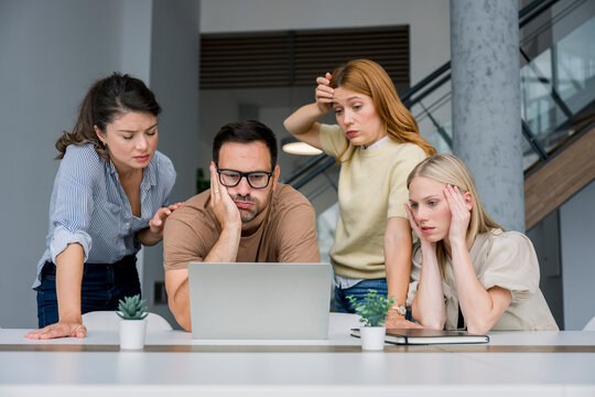 Business team stressed while looking at charts on laptop