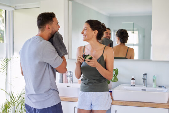Happy smiling couple talking in bathroom in the morning